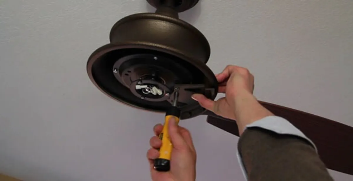 Electrician installing ceiling fan mounting bracket and fixture in Ogden, UT