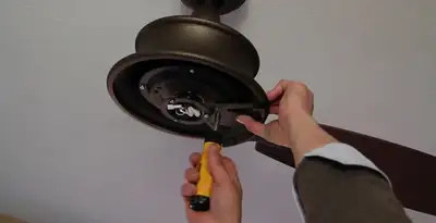 Electrician installing ceiling fan mounting bracket and fixture in Ogden, UT