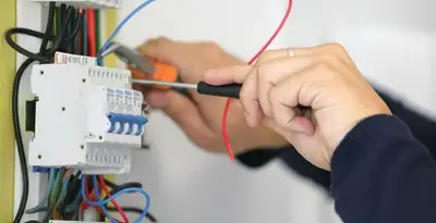 Electrician installing and adjusting circuit breakers in an electrical panel in Ogden, UT