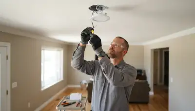 Electrician connecting ceiling fixture wiring in an Ogden, UT home during professional lighting installation