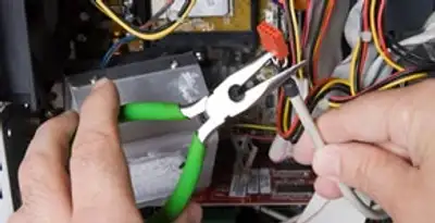 Licensed electrical contractor performing electrical repair with tools in Layton, UT