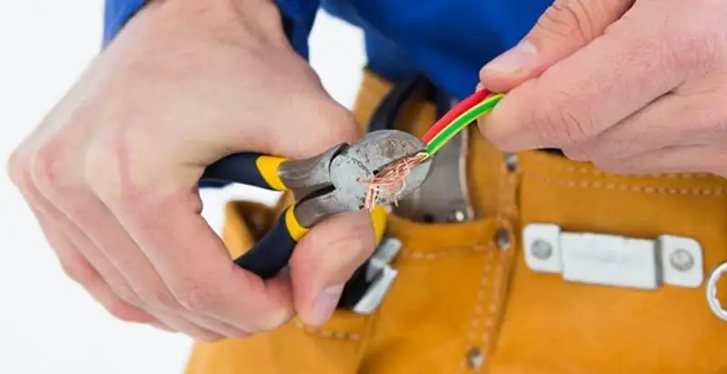 licensed electrician securing electrical wiring with professional tools during service work in Ogden, UT