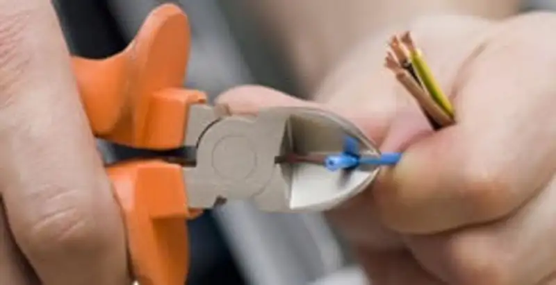 licensed electrician performing precise wire cutting and preparation during electrical service in Ogden, UT