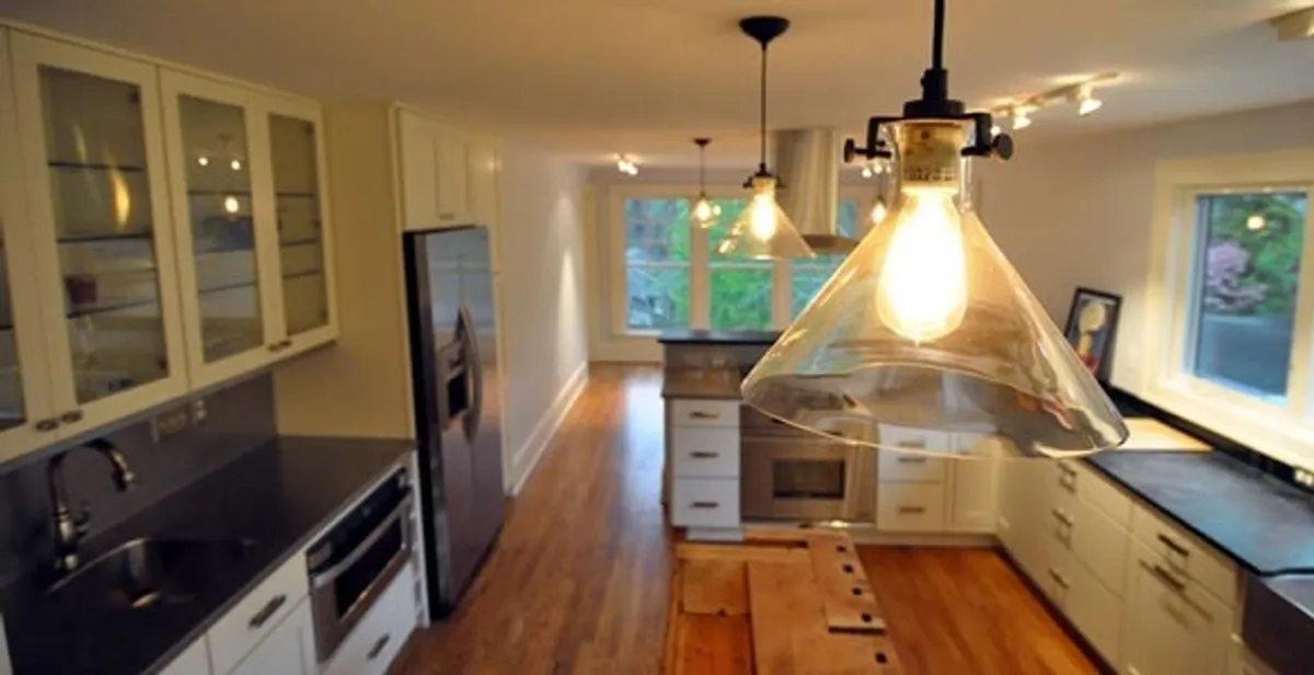 Residential electrician installing modern indoor light fixture in a home in Ogden, UT