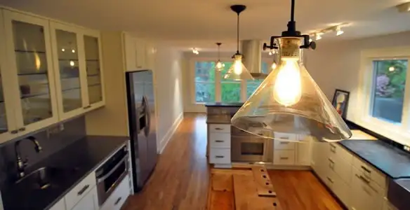 Residential electrician installing modern indoor light fixture in a home in Ogden, UT
